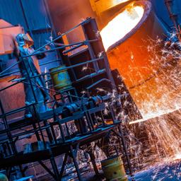 Ein Arbeiter in einem Schutzanzug arbeitet in einer Eisengießerei