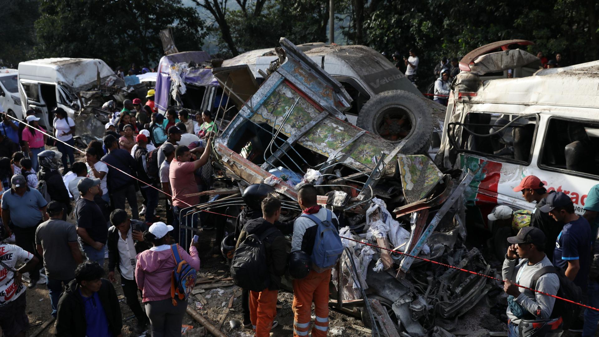 Menschen versammeln sich um Fahrzeuge, die bei einem Anschlag In Kolumbien beschädigt wurden | Santiago Saldarriaga/AP/dpa