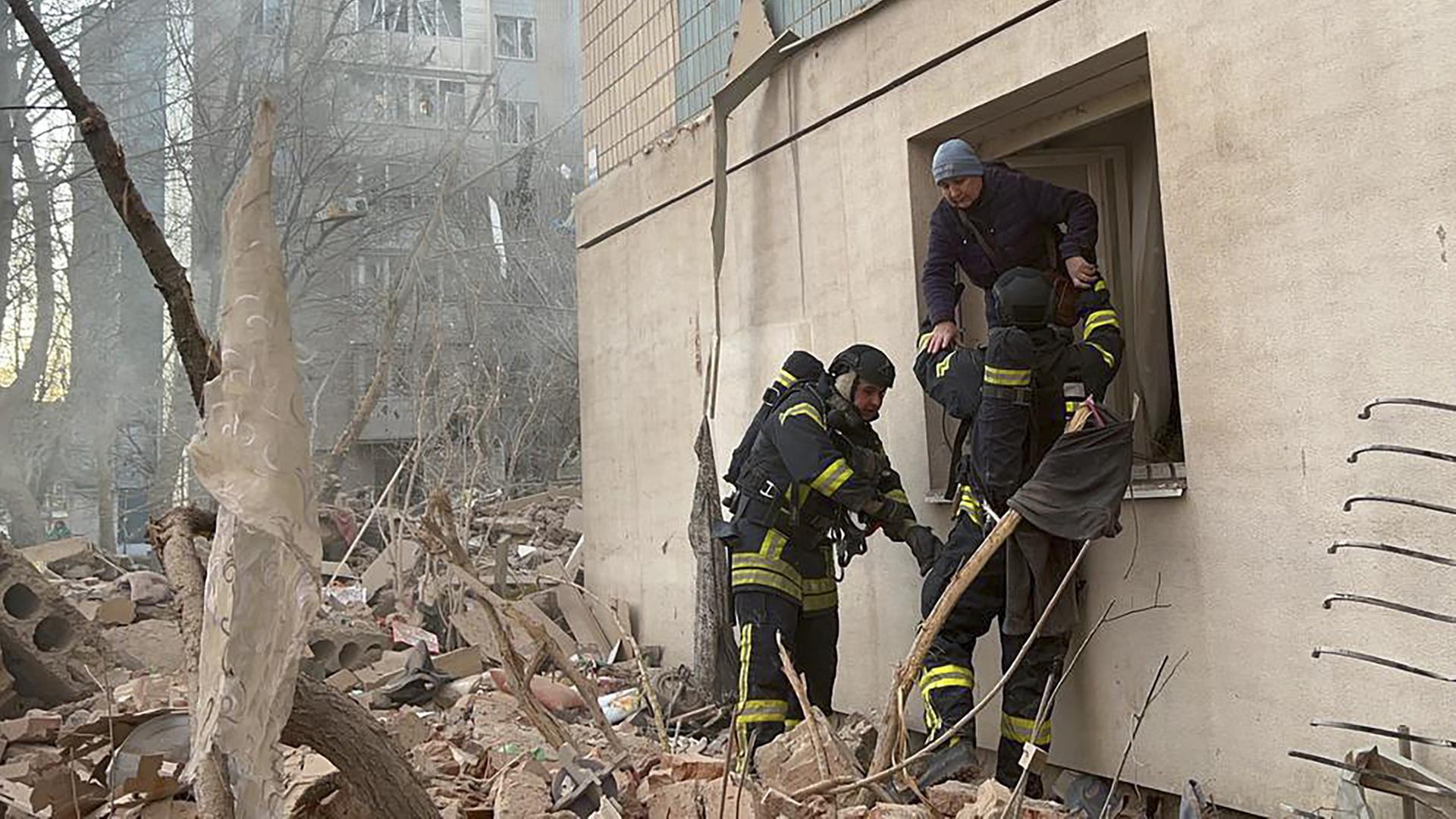 Ein von der ukrainischen Nationalpolizei über Telegram zur Verfügung gestelltes Foto zeigt ukrainische Rettungskräfte, die einem Mann aus einer Wohnung in Ternopil im Westen der Ukraine helfen. | EPA
