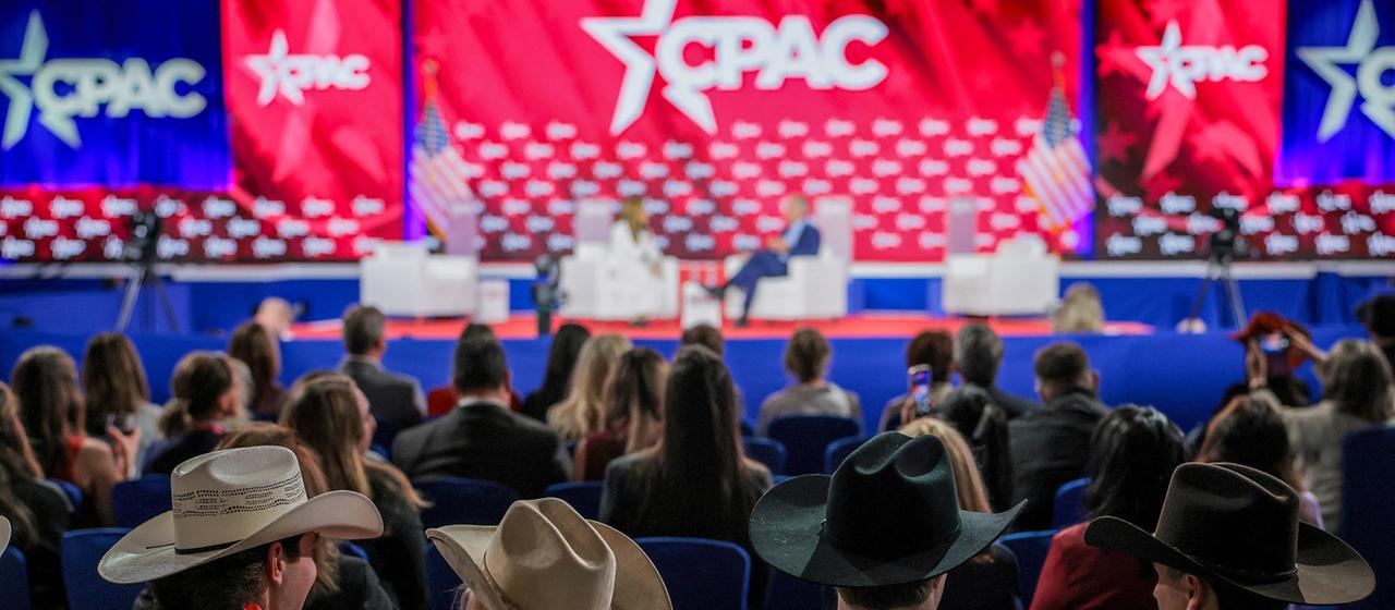 Menschen hören auf der CPAC-Konferenz in Texas einem Gespräch zu.