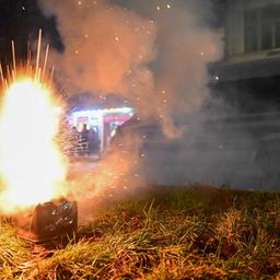 Silvesterfeuerwerk explodiert während der Silvesternacht in Neukölln vor einem Polizeiauto.