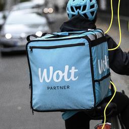 Eine Fahrradkurierin ist für den Essenslieferdienst Wolt, ein finnisches Startup, in einer Straße in Berlin-Mitte unterwegs.