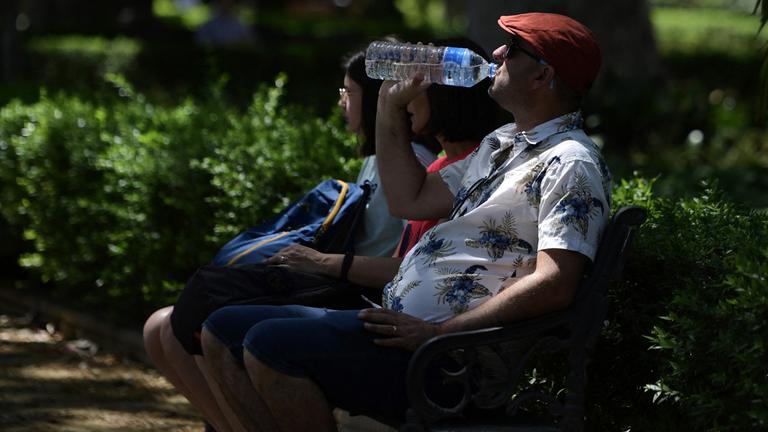 Ein Mann trinkt im spanischen Sevilla aus einer Wasserflasche.