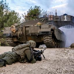 Ein israelischer Soldaten liegt im Gazastreifen mit einem Gewehr auf dem Bauch bei einem Kampfpanzer