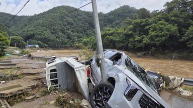 Ein Auto ist nach einem Erdrutsch in Südkorea an einem Mast hängen geblieben.