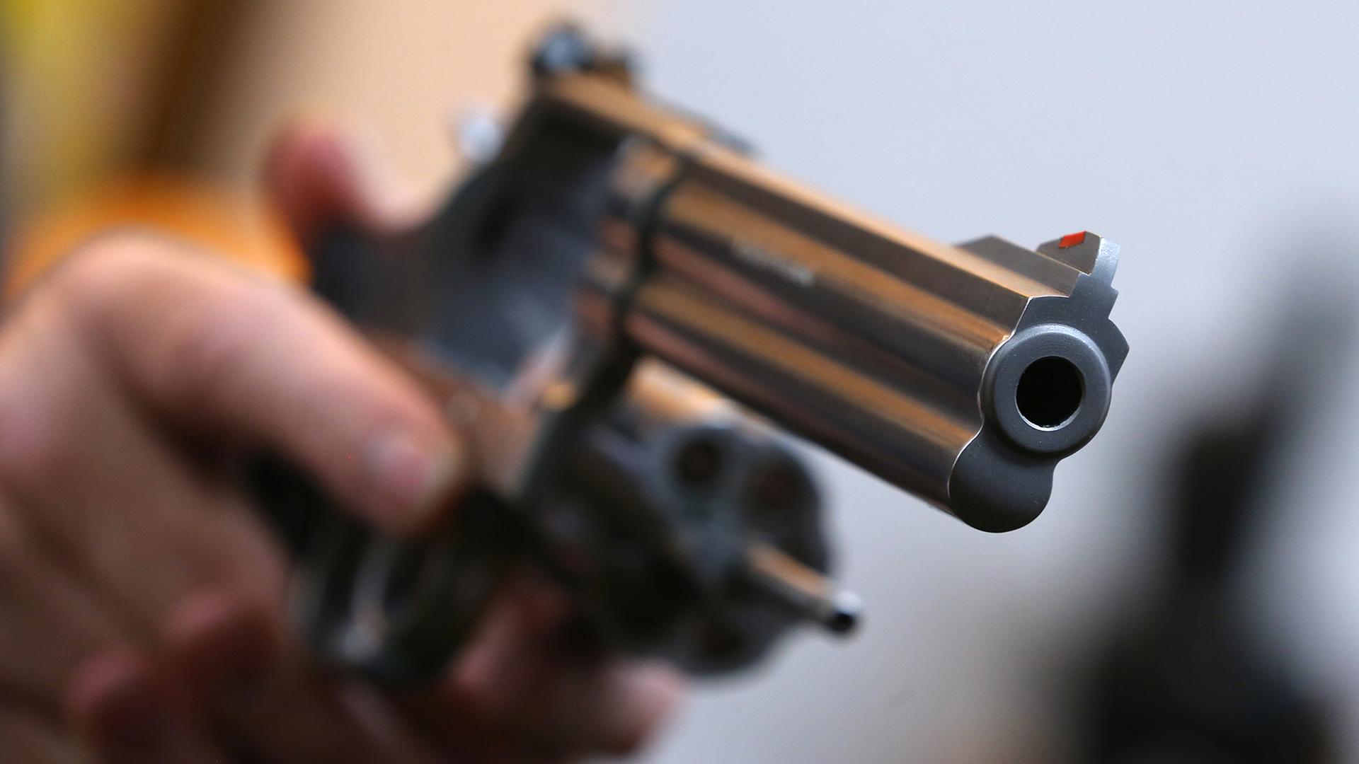 Ein Mann hält eine Waffe | picture alliance / dpa