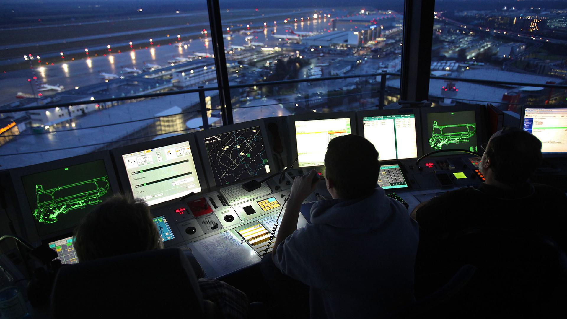 Fluglotsen arbeiten am Flughafen Düsseldorf bei Nacht. | dpa