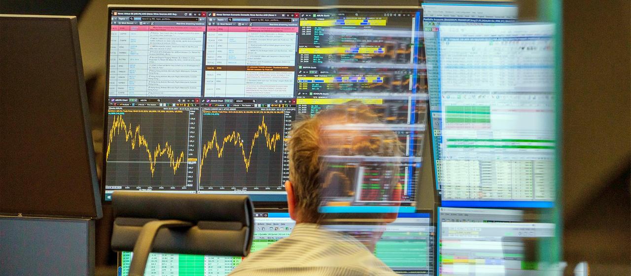 Ein Händler an der Frankfurter Börse vor Computermonitoren mit Kursdaten.