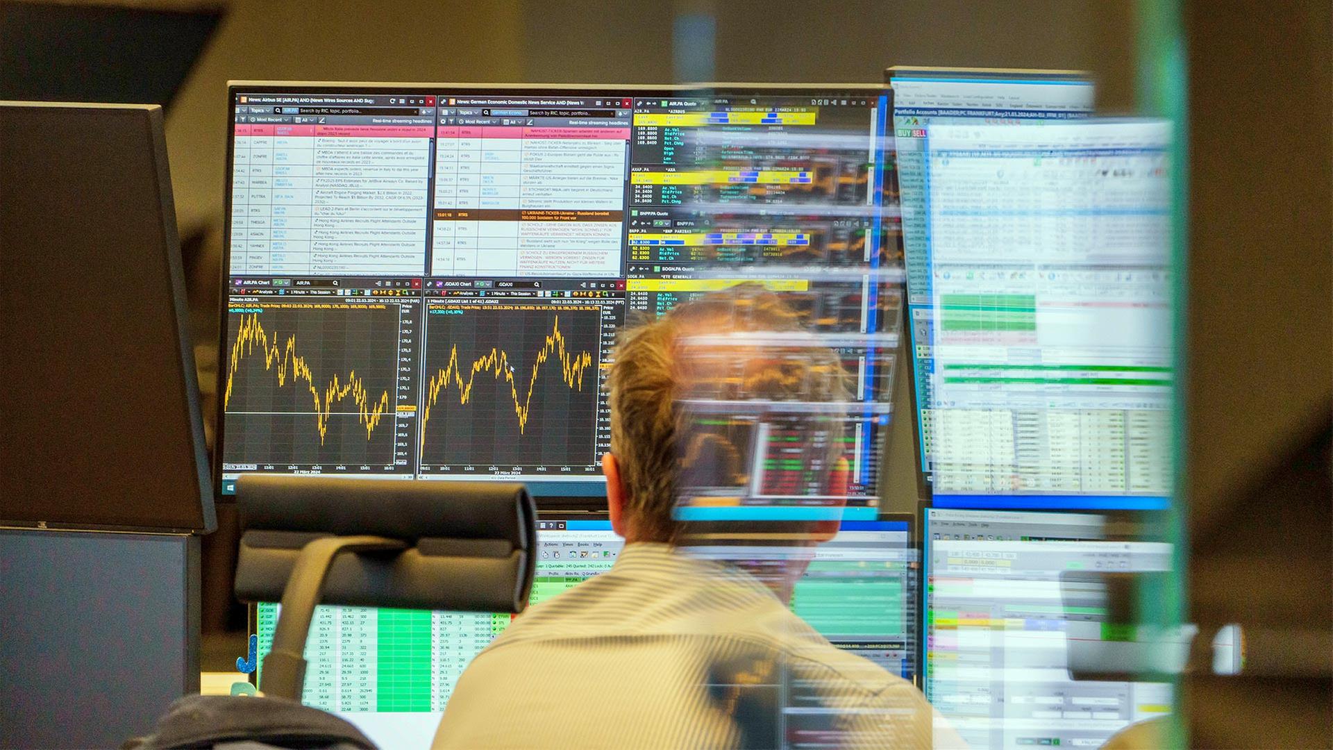 Ein Händler an der Frankfurter Börse vor Computermonitoren mit Kursdaten. | picture alliance/dpa