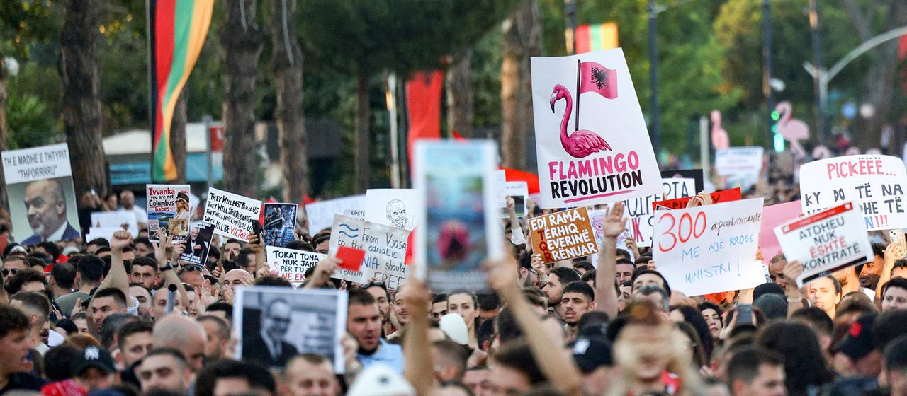 Demonstranten halten Transparente während einer Protestkundgebung hoch.