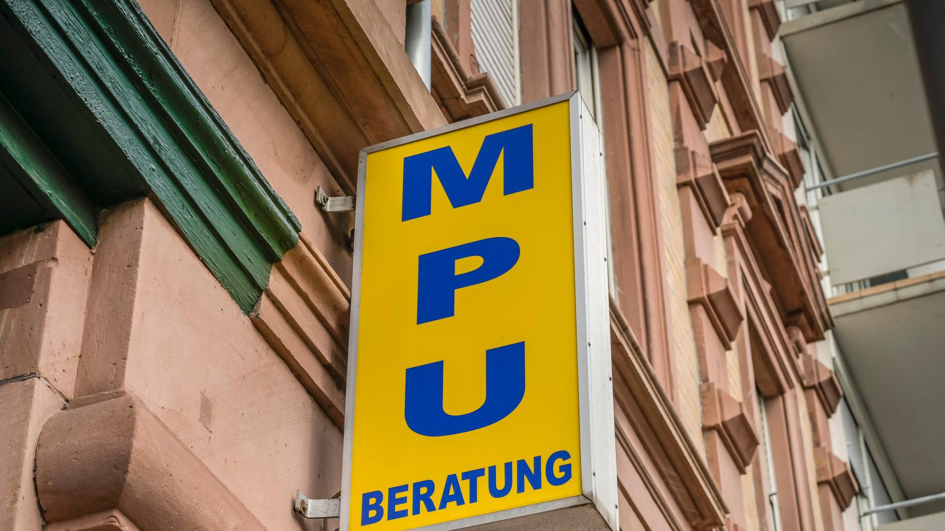 Ein gelbes Schild an einer Gründerzeit-Hausfassade: Darauf steht in blauen Gro0buchstaben 