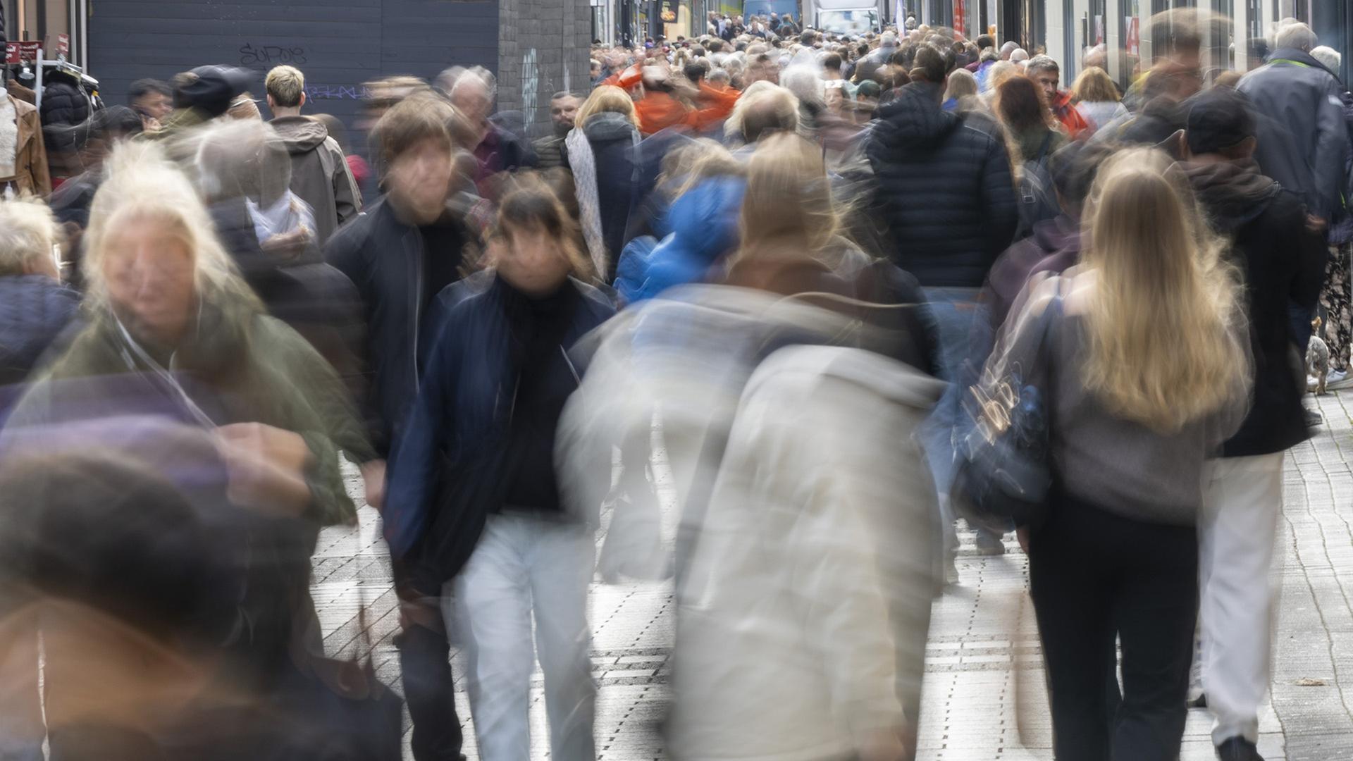 Passanten in einer Fußgängerzone | dpa