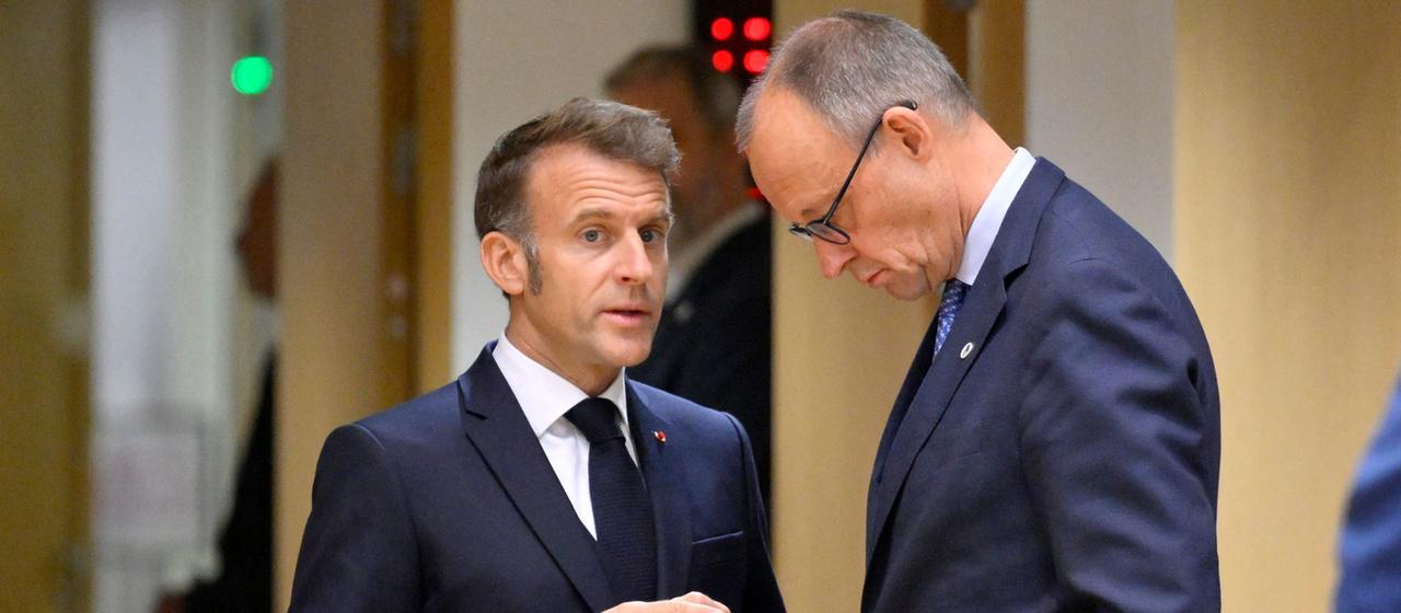 Friedrich Merz hört mit gesenktem Kopf Emmanuel Macron zu. | AFP Friedrich Merz hört mit gesenktem Kopf Emmanuel Macron zu.