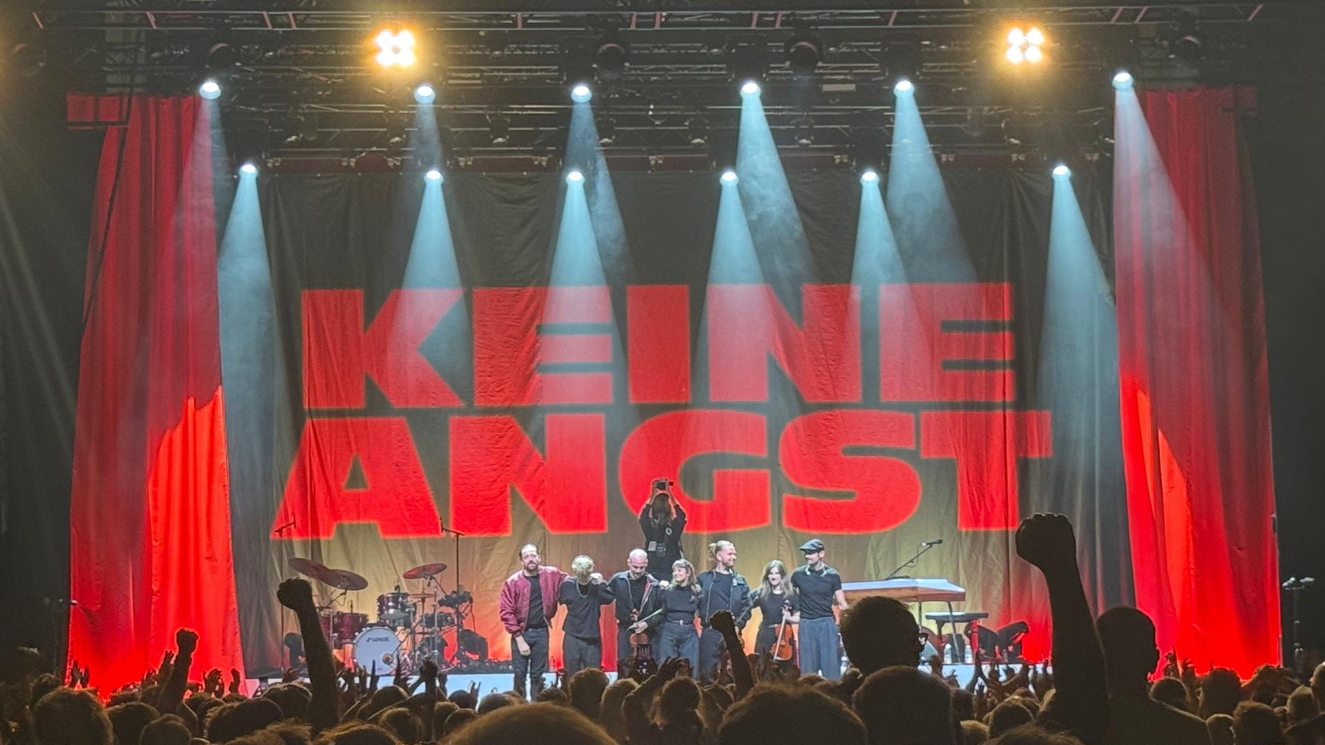 Musiker Danger Dan mit Band auf einer Bühne mit Schriftzug 