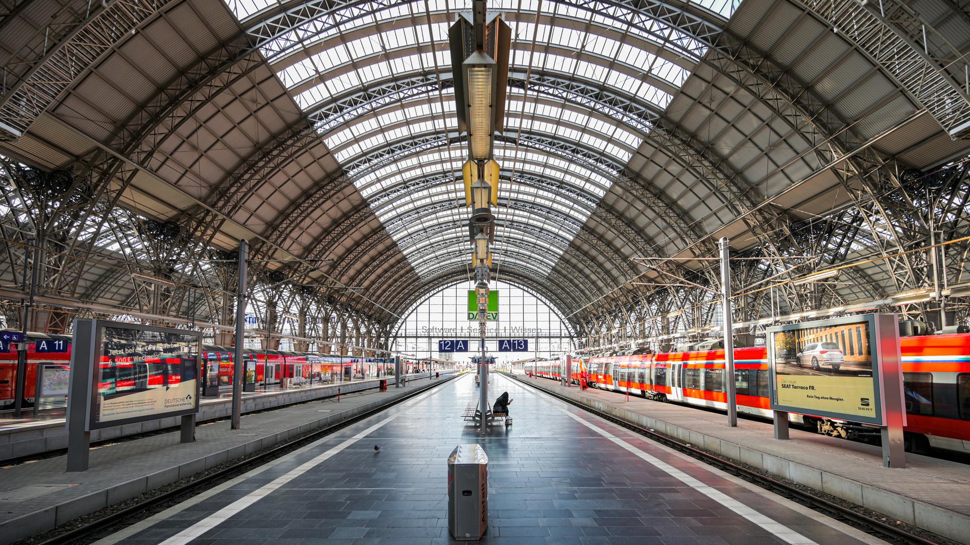 Eine Frau sitzt einsam an einem Gleis im Frankfurter Hauptbahnhof. | picture alliance/dpa | Andreas Arnold