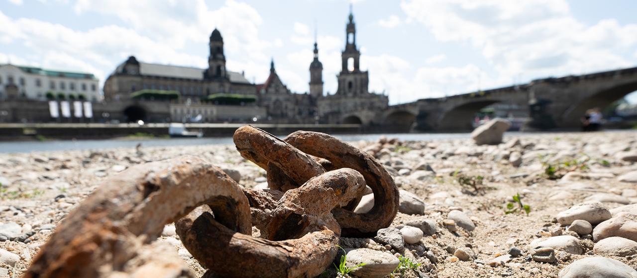   A rusty chain lies in the dry riverbed on the bank of a city. (Archive image: June 26, 2025)