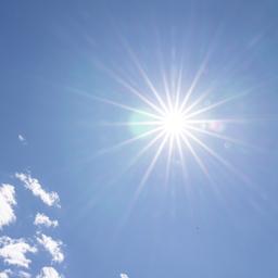 Die Sonne scheint am blauen Himmel mit Wolken.