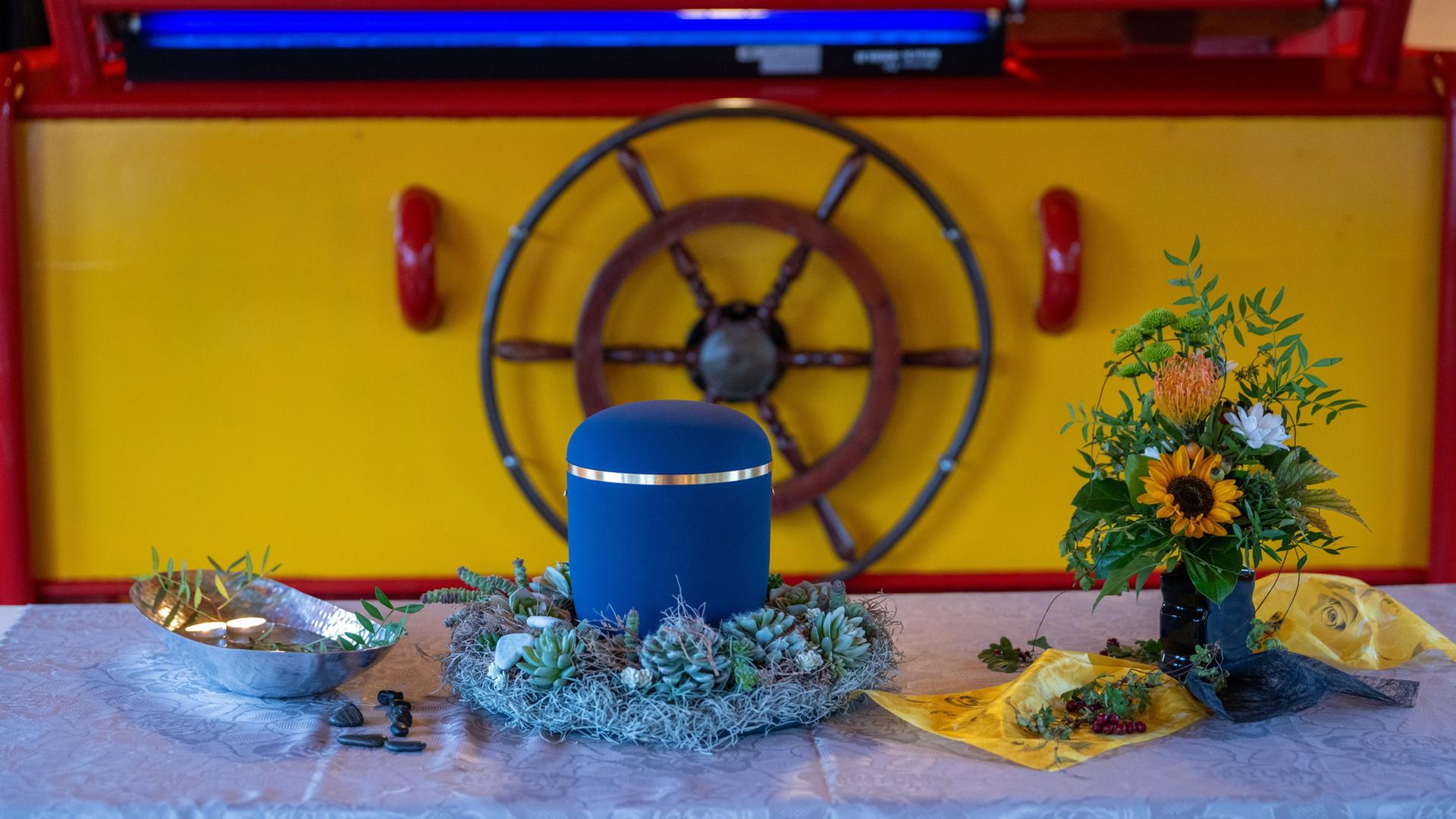 Eine Urne steht dekoriert an Bord der Telegraaf IV, einem ehemaligen Postfrachtschiff auf der Mosel. (Archiv) | Harald Tittel/dpa