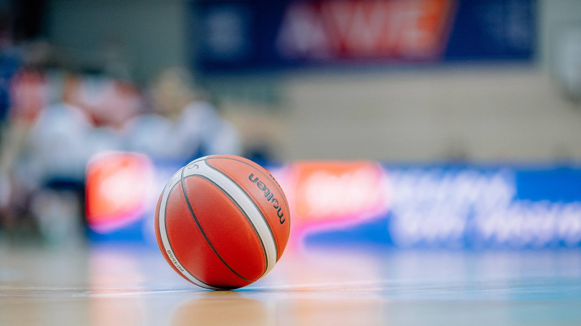 Ein Basketball auf einem Hallenboden. | IMAGO / Hartmut Bösener