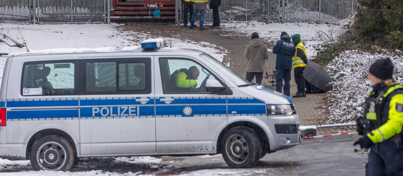 Einsatzkräfte der Polizei stehen an der Brandstelle einer Kabelbrücke in Berlin