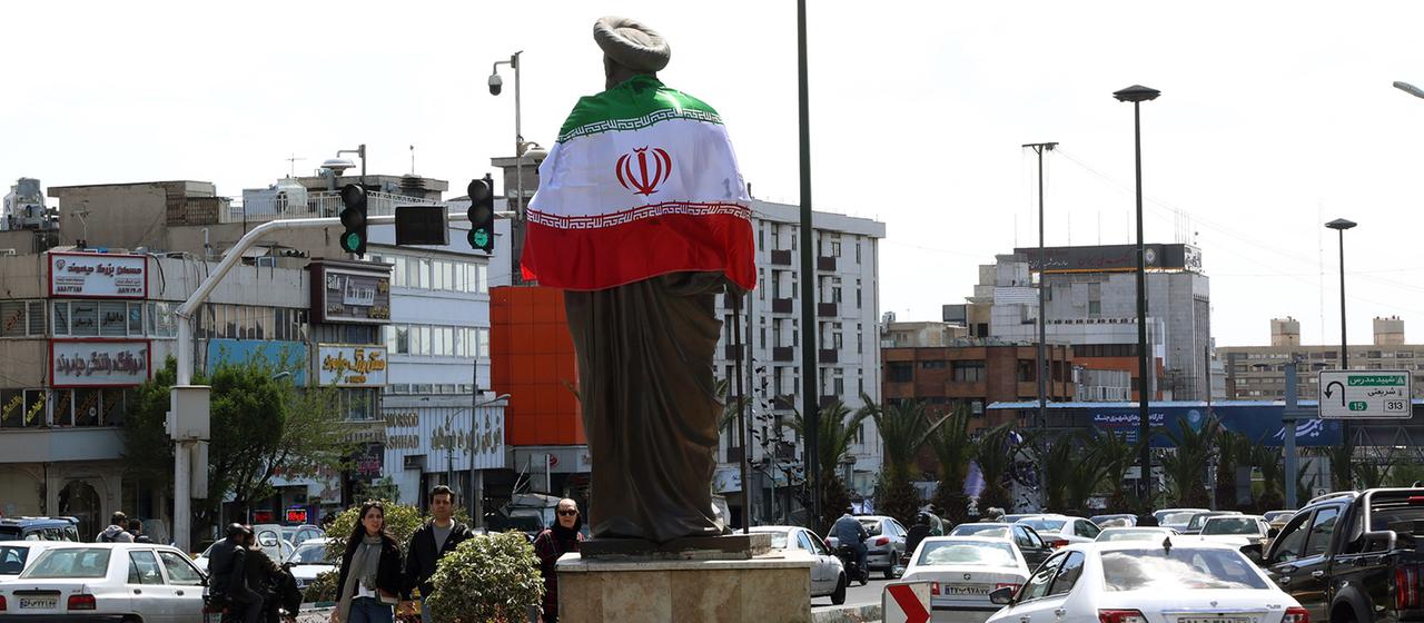The Iranian flag is wrapped around a statue in Tehran.