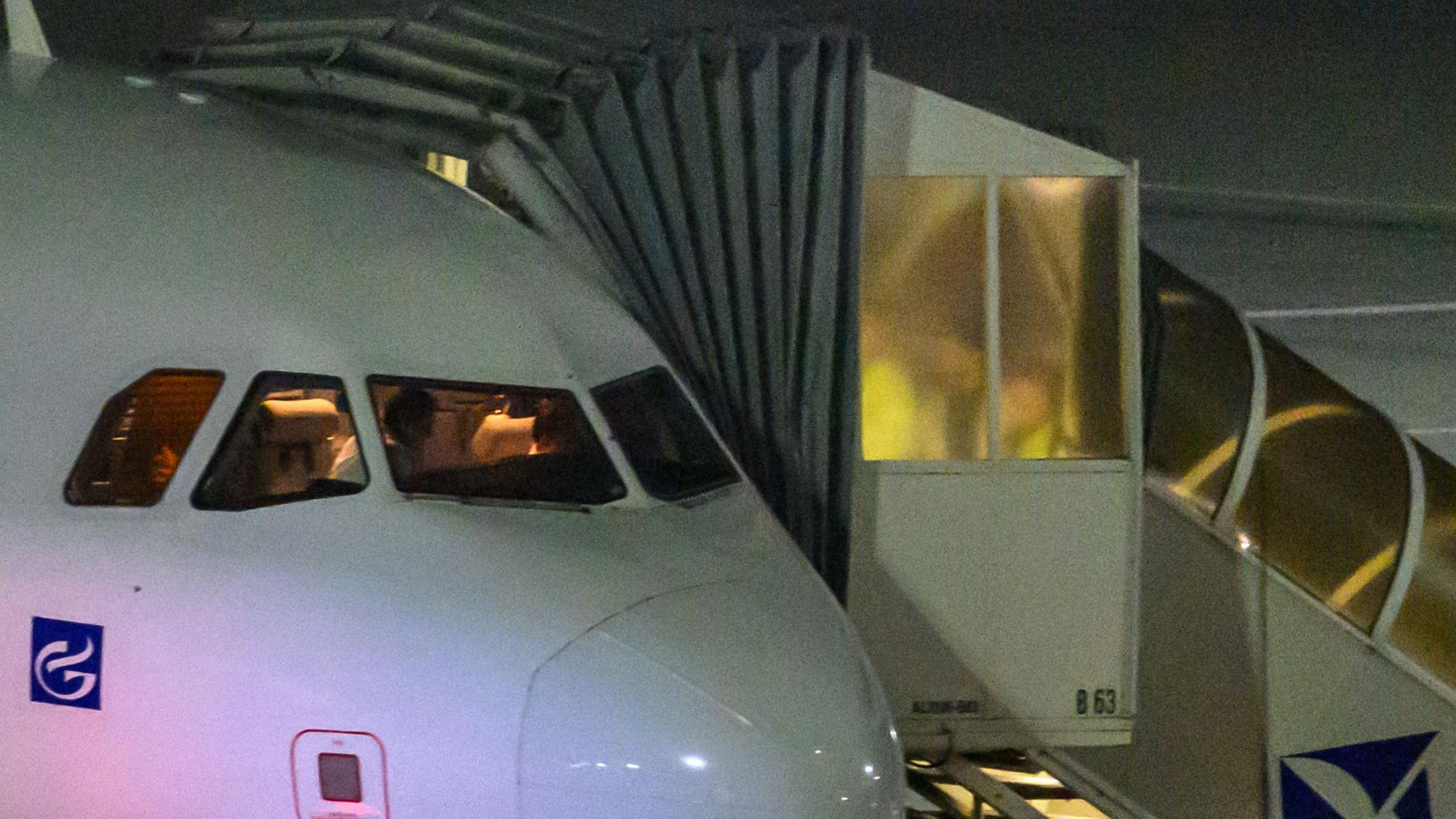 Ein Passagier wird auf dem Flughafen Leipzig/Halle in ein Flugzeug begleitet. | Hendrik Schmidt/dpa