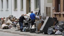 Bewohner eines Hauses in Saarbrücken bringen zerstörte Möbel und Hausrat auf die Straße