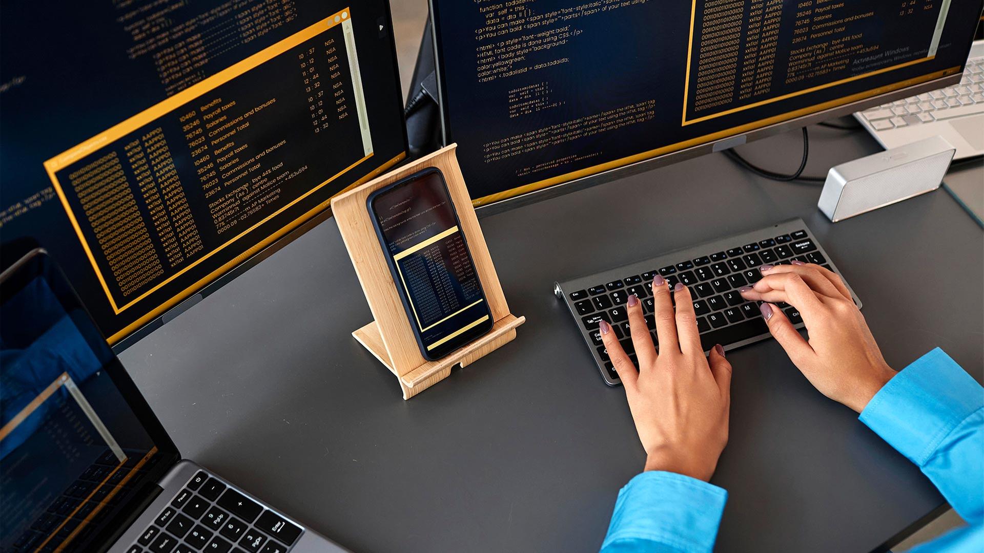 Programmiererin arbeitet an verschiedenen Bildschirmen. | picture alliance / Westend61