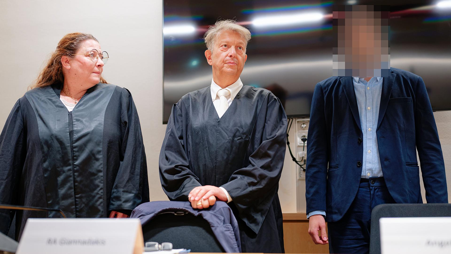 Der Angeklagt (r.) steht im Gerichtssaal neben seinen Anwälten | Uwe Anspach/dpa