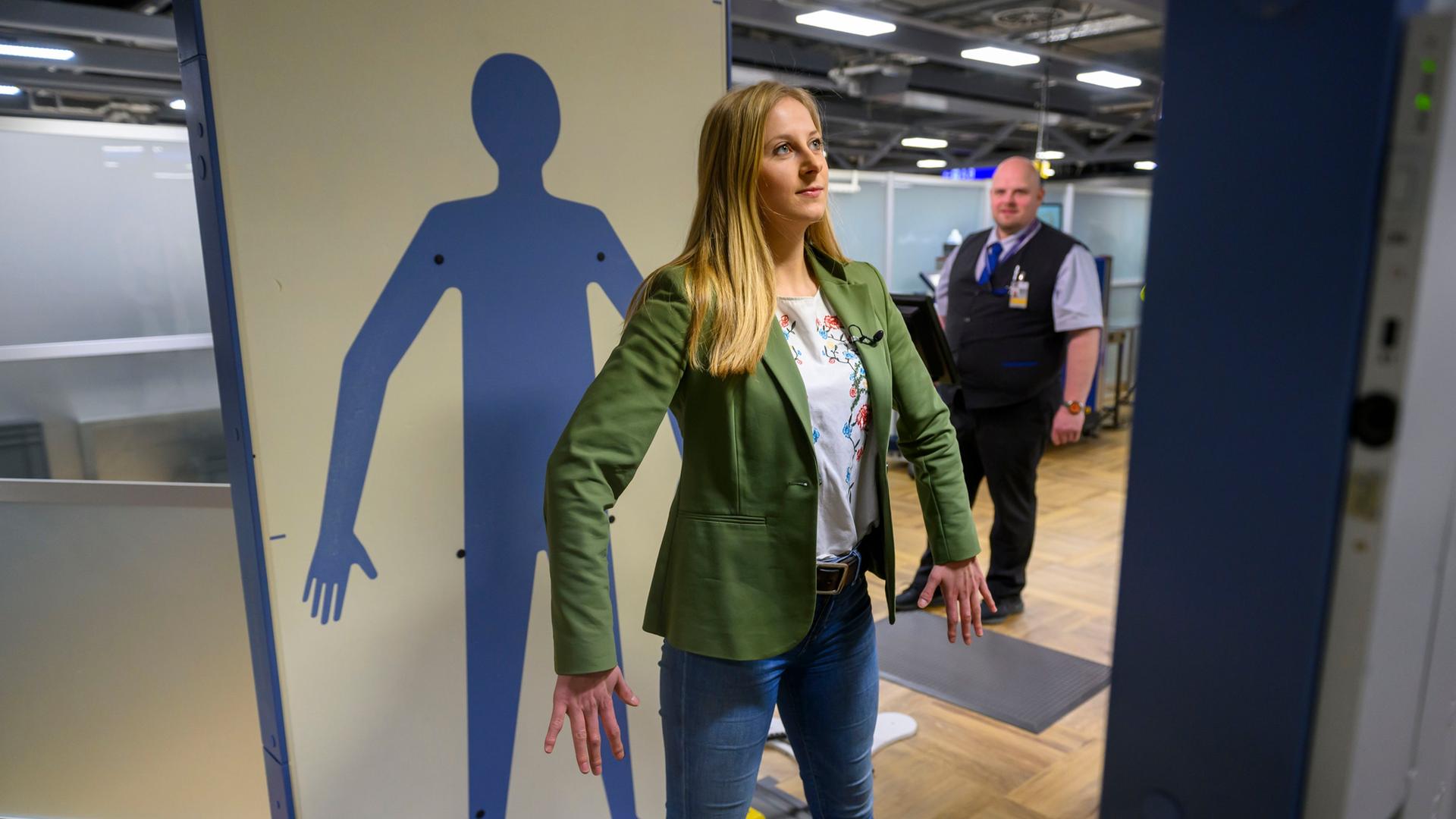 Eine Frau mit langen hellen Haaren steht in einem Ganzkörperscanner am Flughafen Frankfurt. | picture alliance / Kirchner-Media | Christopher Neundorf