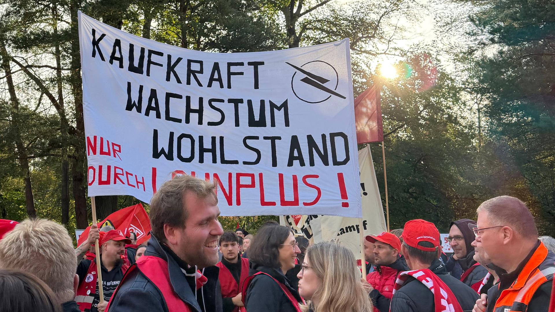 Menschen mit roten Westen und Mützen sowie Plakaten | Gaby Beck (hr)