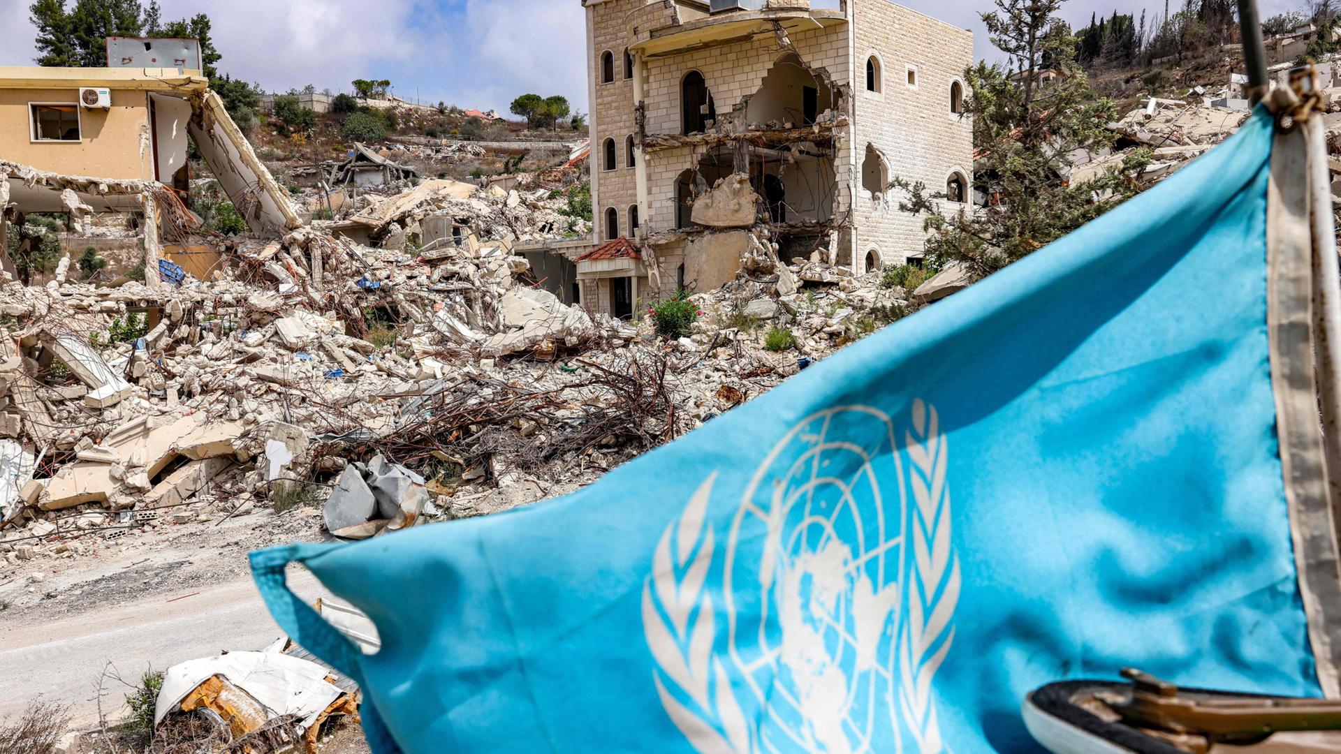 Eine UN-Flagge vor Trümmern im Libanon. | AFP