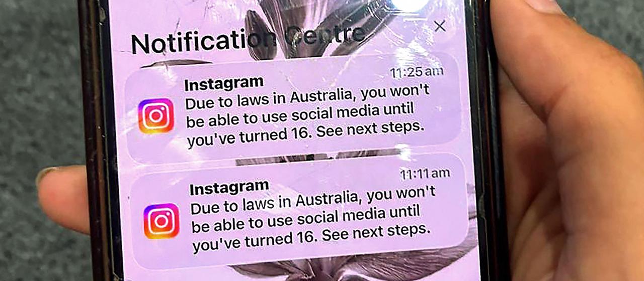 Ein Teenager hält ein Mobiltelefon mit einer Nachricht der Social-Media-Plattform Instagram in der Hand