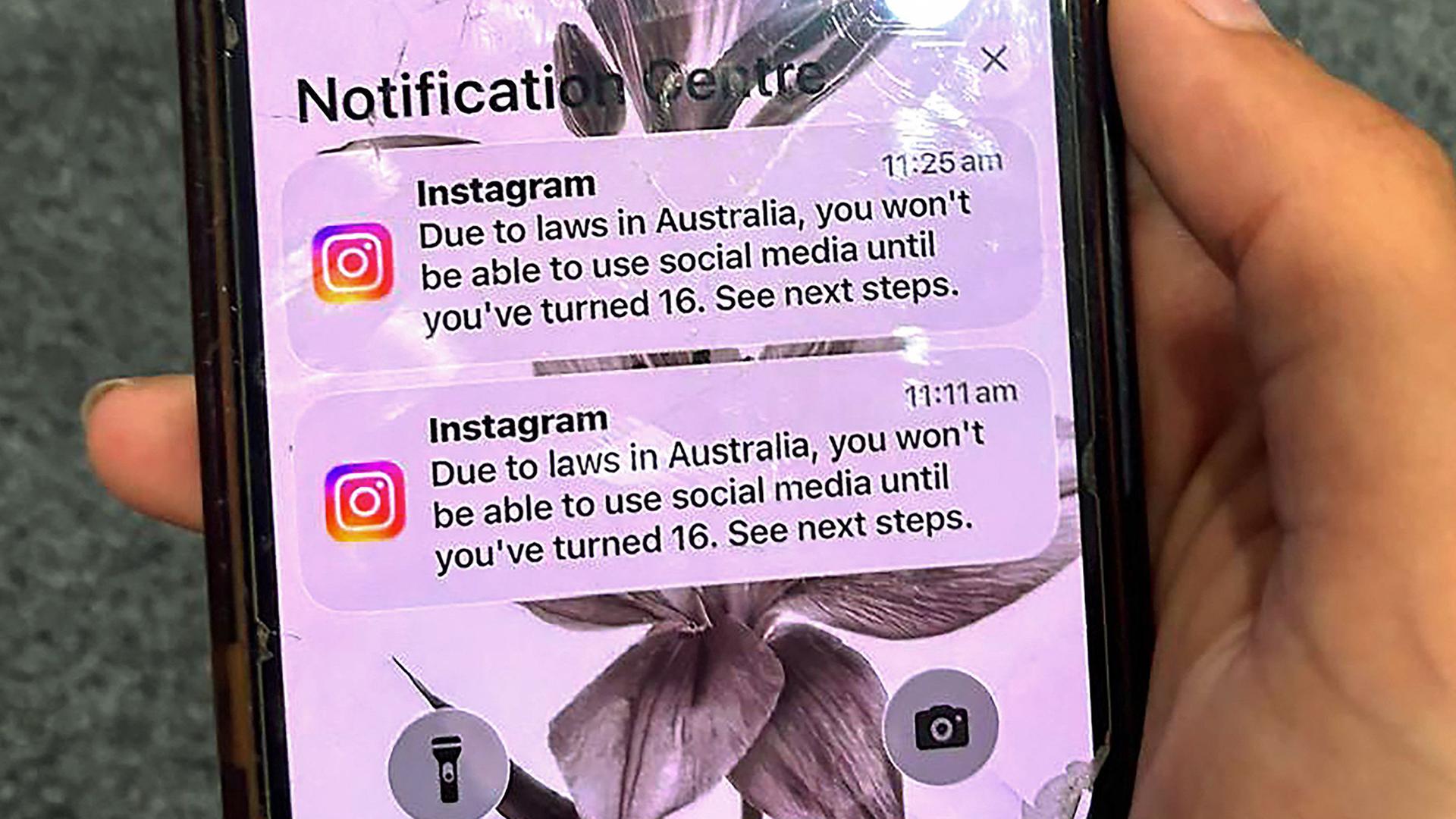 Ein Teenager hält ein Mobiltelefon mit einer Nachricht der Social-Media-Plattform Instagram in der Hand | AFP