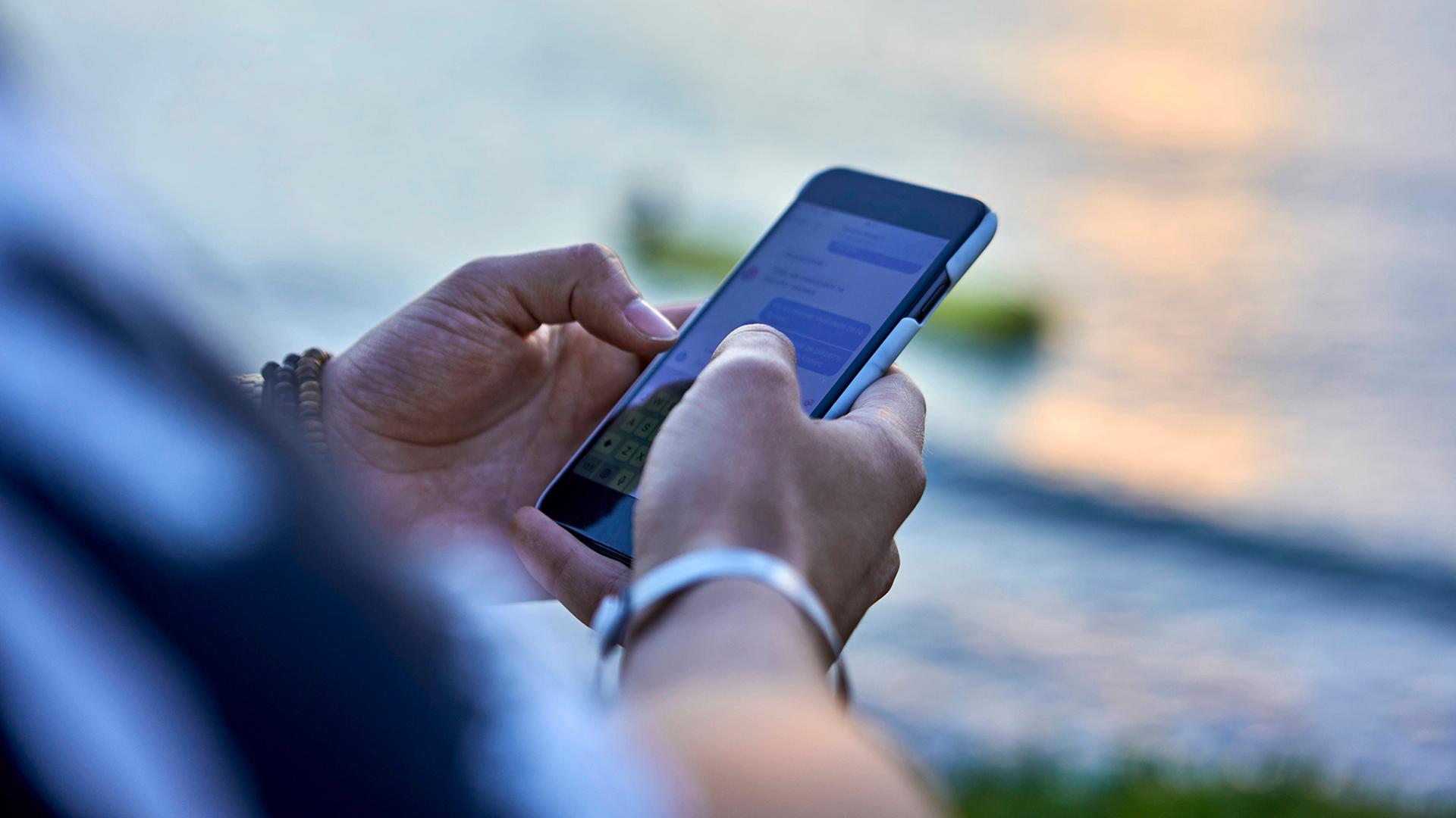 Hände benutzen ein Smartphone. | picture alliance / Westend61