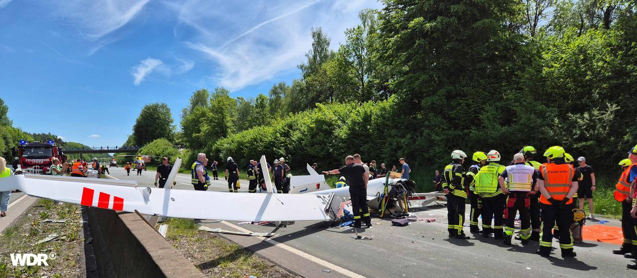 Das Segelflugzeug auf der Fahrbahn, viele Rettungskräfte sind zu sehen