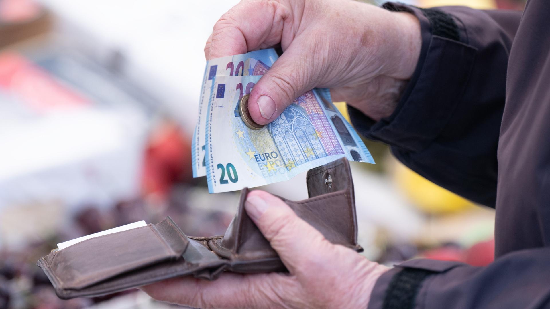 Eine Frau sortiert auf einem Wochenmarkt das Wechselgeld fÃ¼r ihre EinkÃ¤ufe in ein Portemonnaie | Sebastian Kahnert/dpa