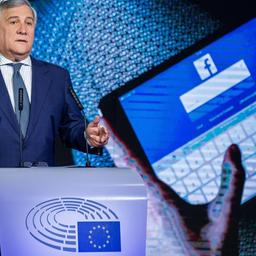 EU-Parlamentspräsident Tajani hält eine Rede, im Hintergrund zeigt ein Foto Hände die sich auf einem Tablet bei Facebook einloggen.
