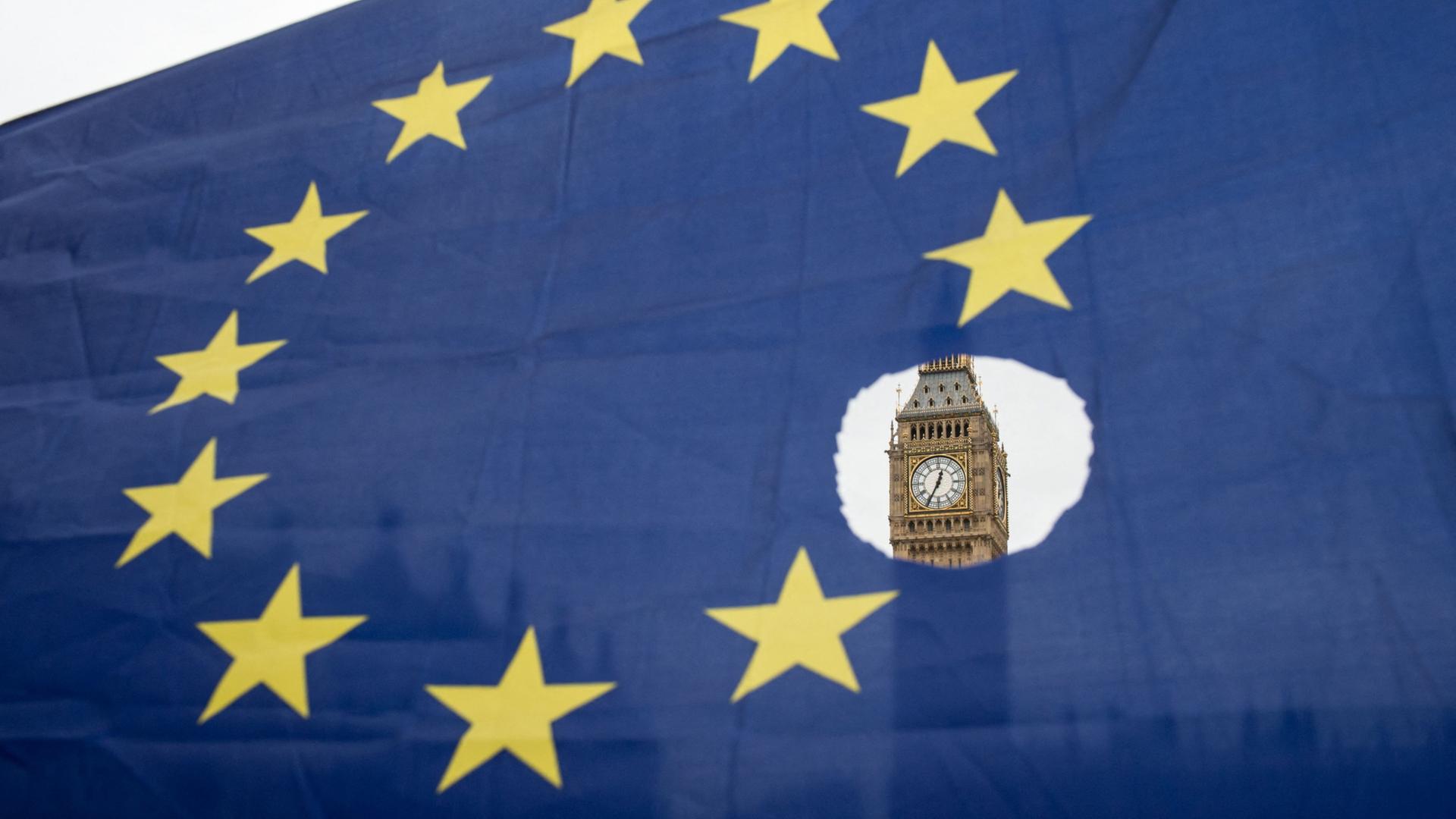 Durch ein Loch in einer EU-Flagge ist der Big Ben in London zu sehen. | AFP