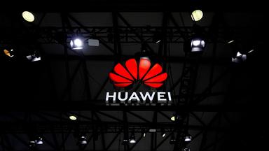 Das Huawei-Logo leuchtet in dunklem Raum.