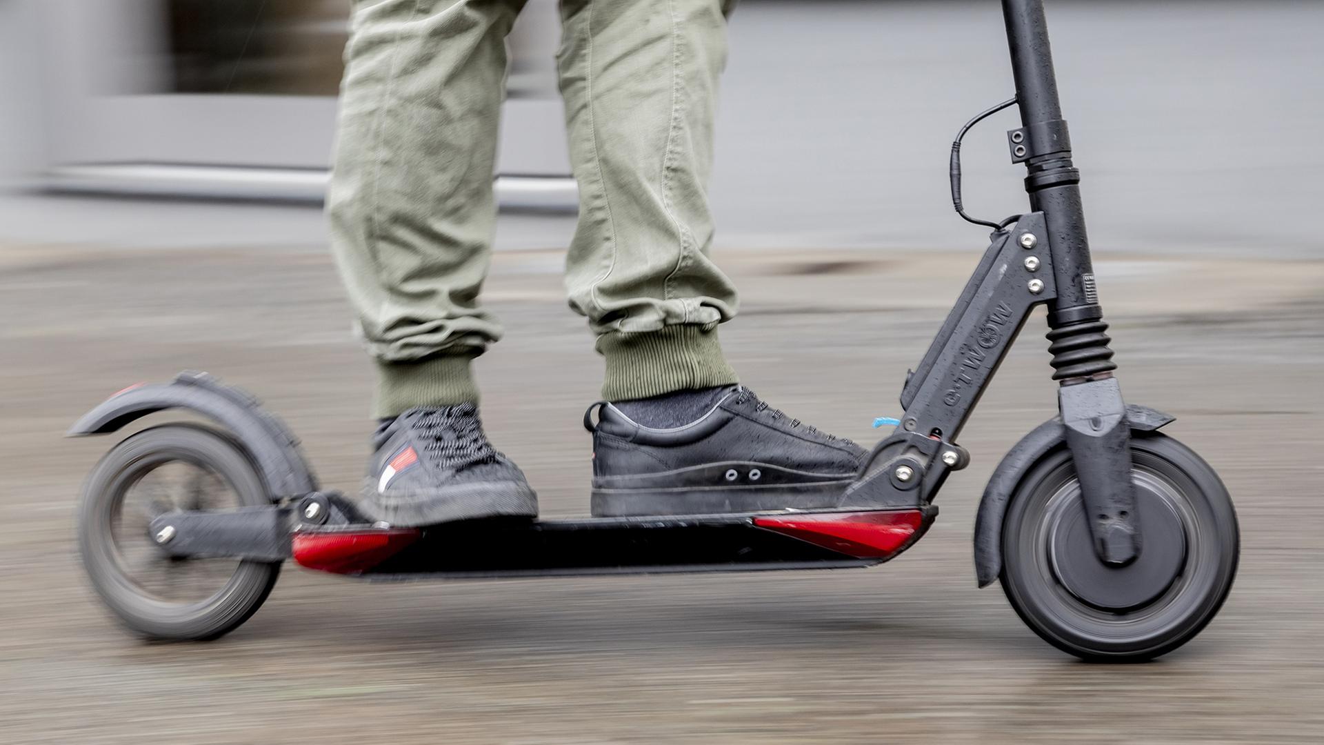 Ein Mann fährt mit einem E-Scooter. | dpa