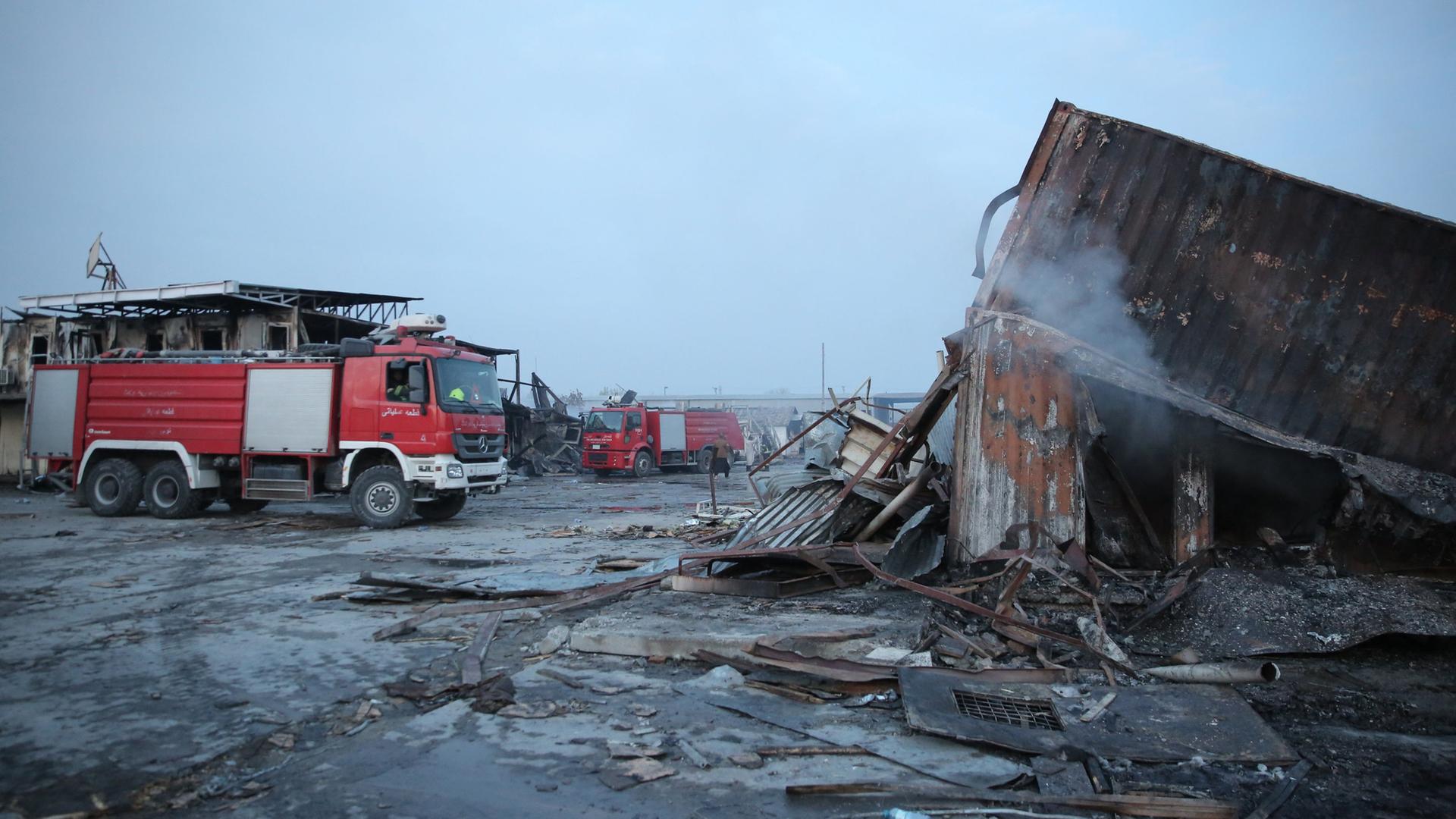 Feuerwehrwagen stehen neben zerstörten Gebäuden. | EPA