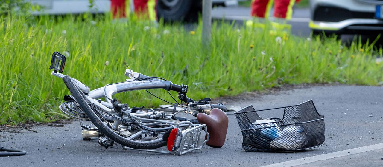 A broken bicycle lies on the road after an accident.