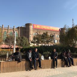 Männer sitzen in Kaschgar in der nordwestchinesischen Region Xinjiang auf einer Mauer