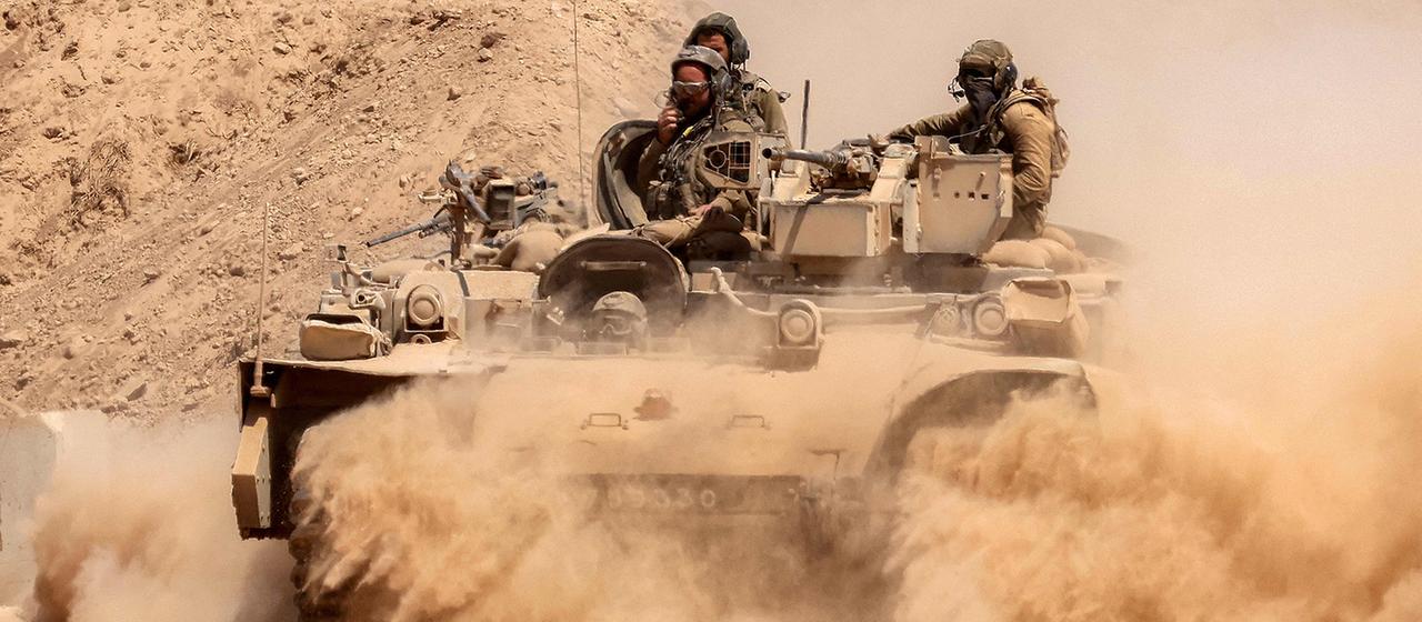 Ein Schützenpanzer der israelischen Armee hinterlässt eine Staubwolke an der Grenze zum Gazastreifen. | AFP Ein Schützenpanzer der israelischen Armee hinterlässt eine Staubwolke an der Grenze zum Gazastreifen.