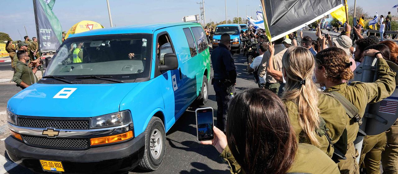 Fahrzeuge mit freigelassenen Geiseln fahren an jubelnden Menschen vorbei.
