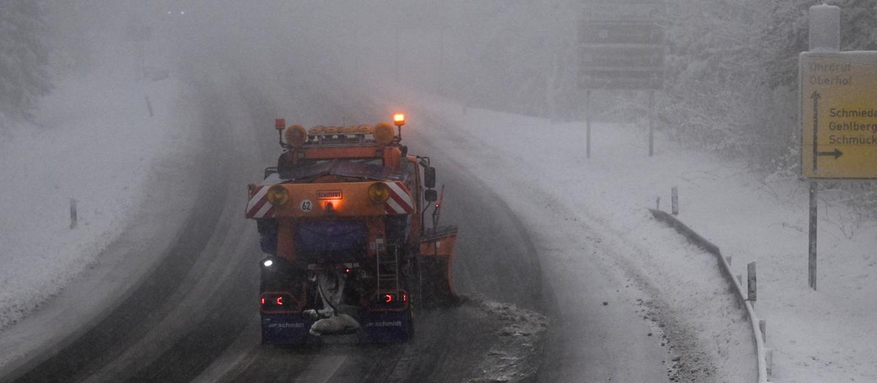 Ein Räumfahrzeug schiebt Schnee auf einer Straße bei Oberhof (Thüringen).