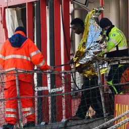 Helfer geleiten einen Mann von Bord des deutschen NGO-Schiffs "Sea-Eye 4". Die deutsche Hilfsorganisation "Sea-Eye" hat 105 gerettete Migranten in der süditalienischen Stadt Neapel an Land gebracht.
