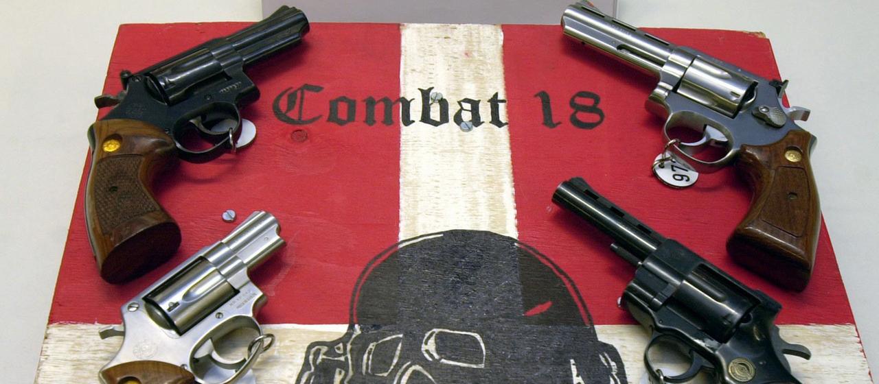 Waffen und ein sichergestelltes Schild der Neonazi Gruppierung ''Combat 18''