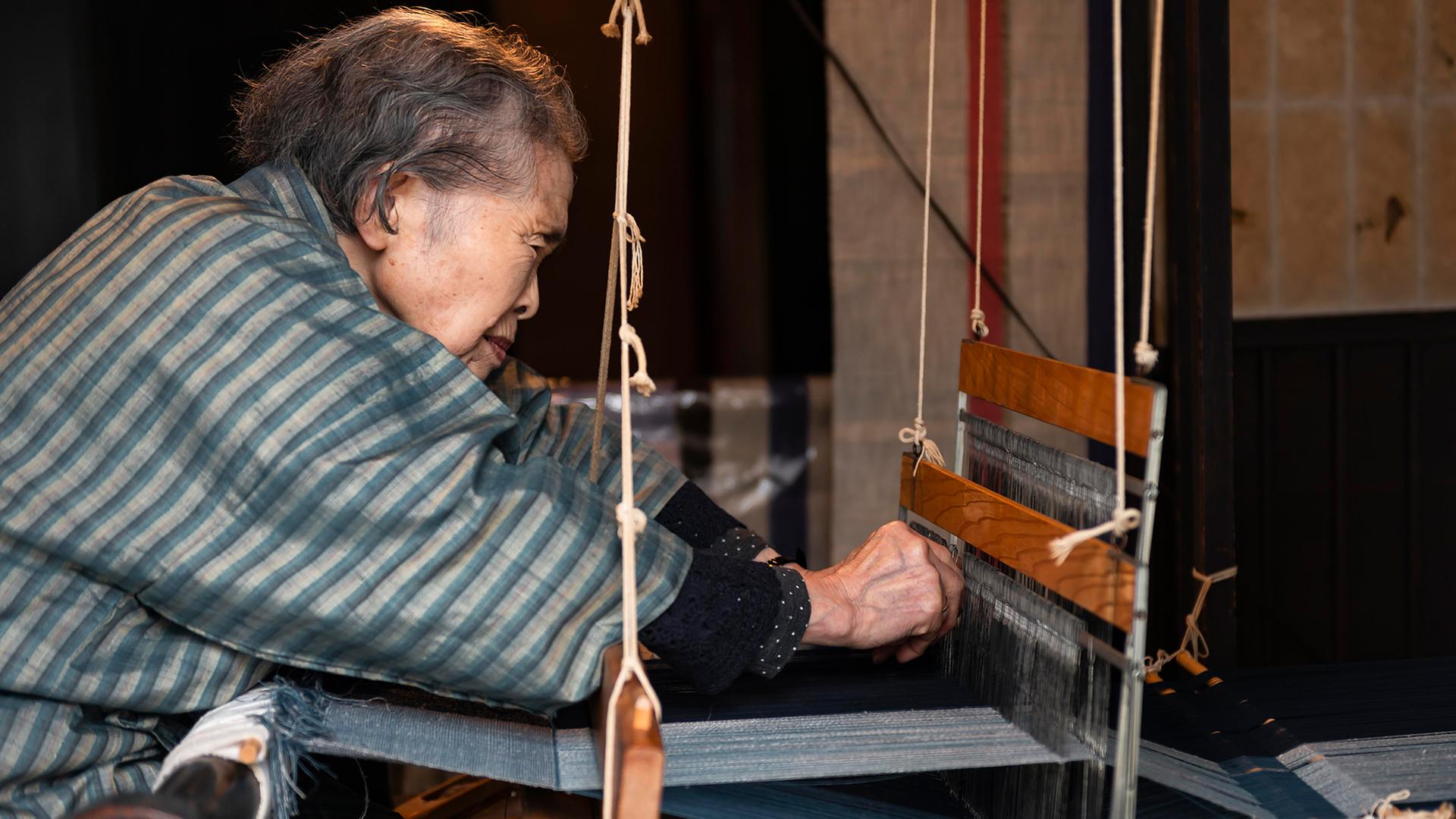 Eine alte japanische Frau beim Weben am Webstuhl. | picture alliance / imageBROKER